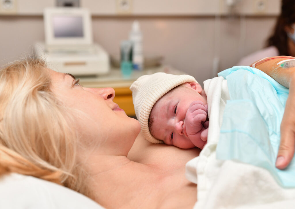 mom holding her newborn baby after delivery in reclined position