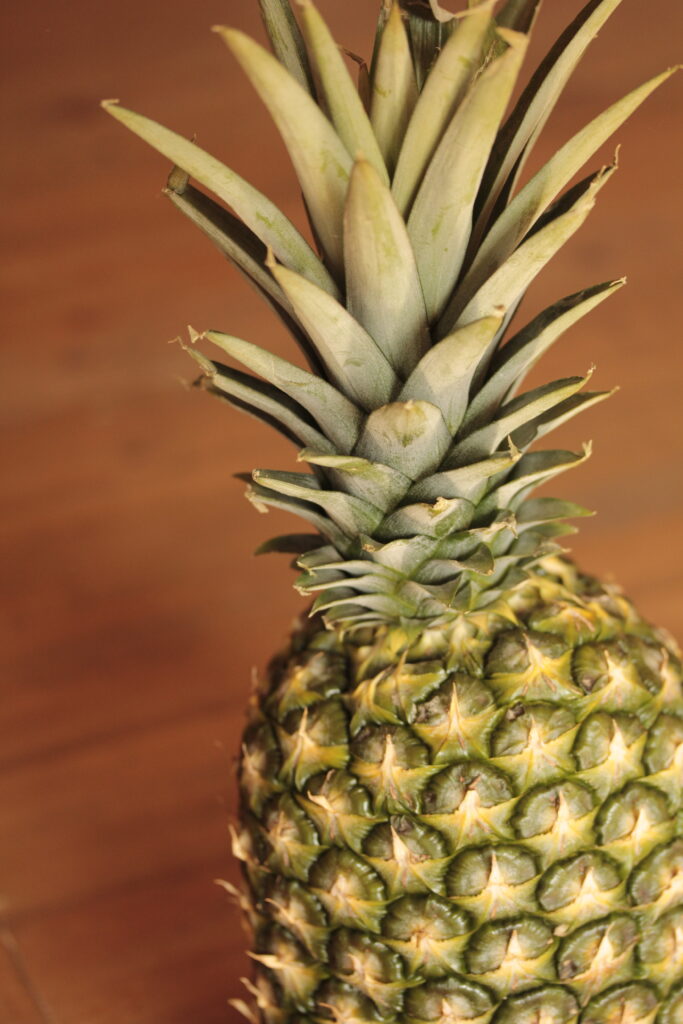 close up photo of a pineapple with wood background